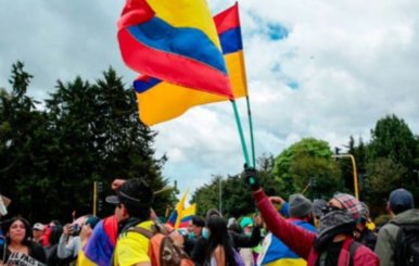 Multitud de personas. Uno de los manifestantes hondea una bandera de Colombia