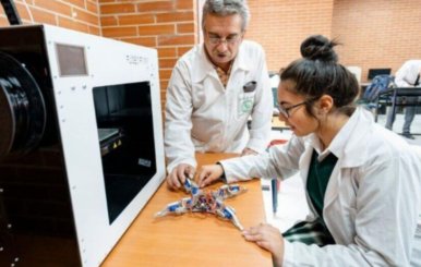 Alumno y profesora con batas de laboratorio 