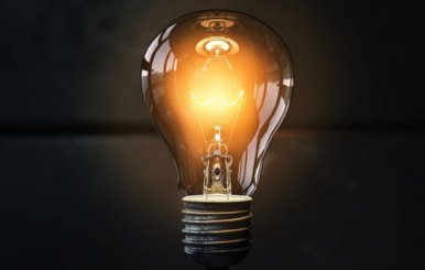 Bombilla de luz encendida en un fondo negro