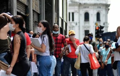 Personas haciendo fila con carpetas en las manos