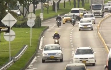 Carretera con carros y motos transitando