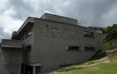 Facha de un colegio: un edificio gris con ventanas de marco rectangular