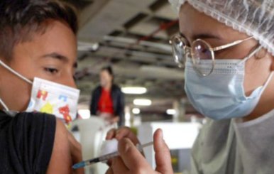 Enfermera inyectando a un niño en el brazo izquiero