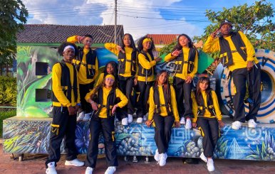 Jóvenes con uniforme amarillo sobre un letrero