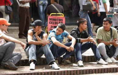 Jóvenes sentados en una acera hablando