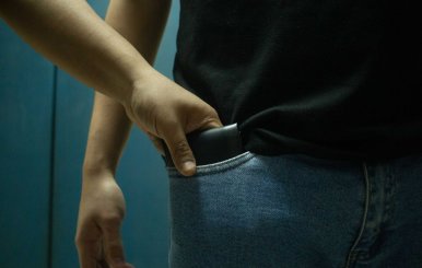 Hombre sacando un celular del bolsillo de otro