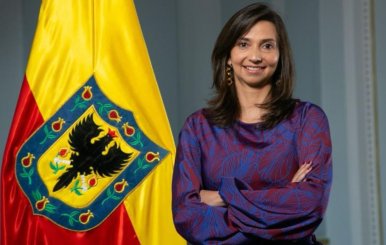 Mujer parada al lado de una bandera de Bogotá