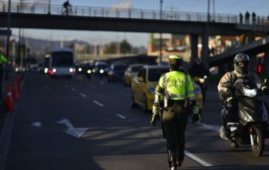 Integrante de la Policía de Tránsito coordinando el plan retorno en una vía principal de la ciudad.