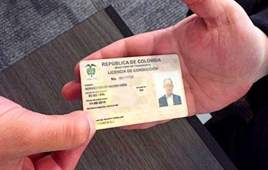 Persona recibiendo la licencia de conducción expedida en Colombia