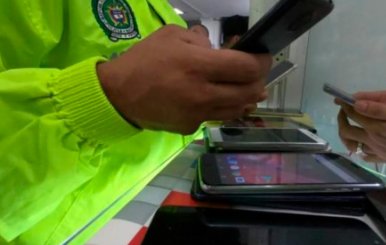 Policía con un celular en la mano