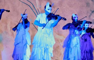 Hombres y mujeres disfrazados como animales tocando instrumentos musicales