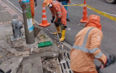 Personal del Acueducto de Bogotá limpiando uno de los sumideros de la ciudad