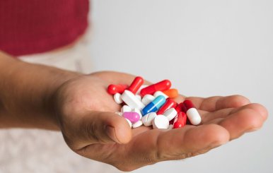 Mano repleta de medicamentos