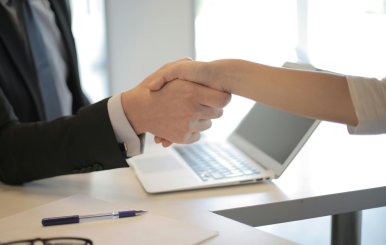 Dos personas estrechándose las manos durante una entrevista de trabajo