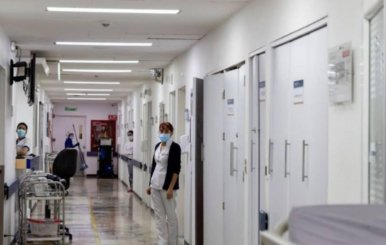 Imagen del pasillo de un hospital en Bogotá con pacientes asomándose desde las puertas de las habitaciones.