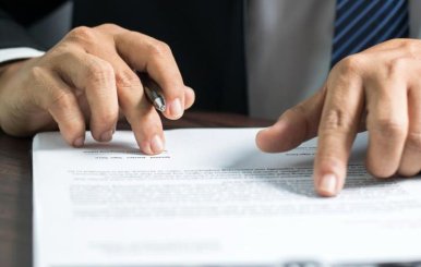 Hombre con una hoja sobre la mesa a punto de firmar