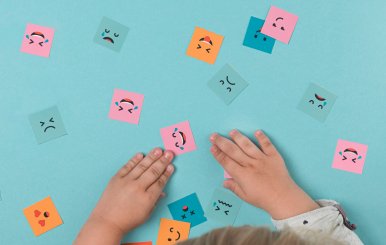 Niño jugando con cuadros con caras dibujadas - Imagen por Freepik