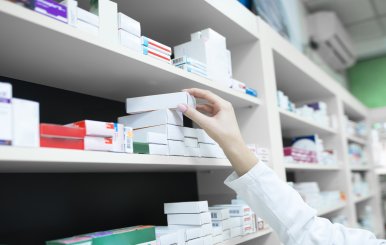 Personas acomodando medicamentos en un a estantería 