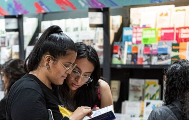 Dos mujeres leyendo libros en la FILBo 