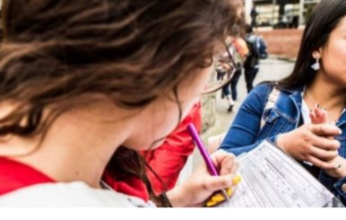 Jóvenes firmando una encuesta