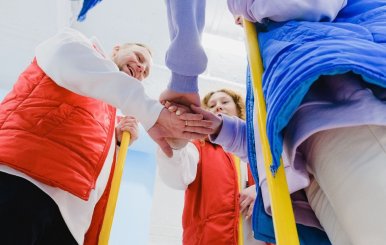 Niños poniendo sus manos una sobre la otra. 