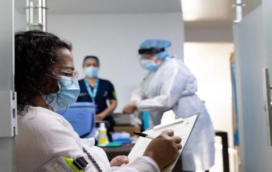 Una mujer del personal médico llena una planilla en las instalaciones de un hospital