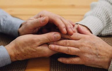 Las manos entrelazadas de dos personas mayores