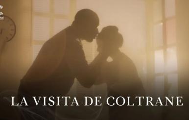 Un hombre besando la frente de una mujer bajo un rayo de sol