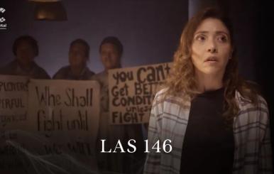 Mujer parada con personas detrás sosteniendo carteles