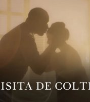 Un hombre besando la frente de una mujer bajo un rayo de sol