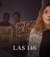 Mujer parada con personas detrás sosteniendo carteles