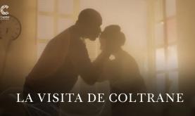 Un hombre besando la frente de una mujer bajo un rayo de sol