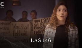 Mujer parada con personas detrás sosteniendo carteles