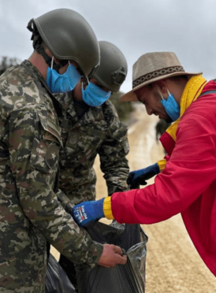 Dos militares sosteniendo una bolsa de basura 
